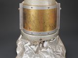 an image of a silver and gold helmet on a rock
