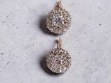 a close up of a pair of earrings on a white surface
