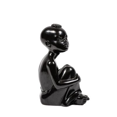 sculpture noire représentant une femme assise à genoux sur un fond blanc