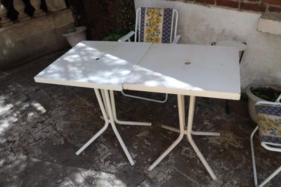 une table blanche et deux chaises disposées sur une terrasse
