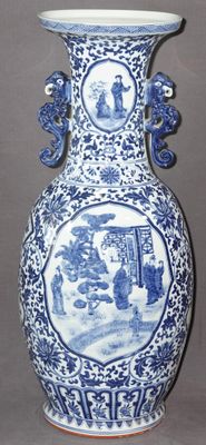 un vase bleu et blanc sur lequel est représenté un homme et une femme