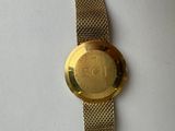 a close up of a gold watch on a white surface