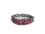 a close up of a pink and black bracelet on a white background