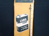 un vieux panneau jaune sur lequel figure un thermomètre et l'inscription « labo »