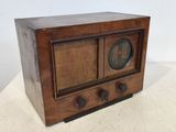 une vieille radio en bois posée sur une table blanche