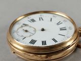 a gold pocket watch with roman numerals on it