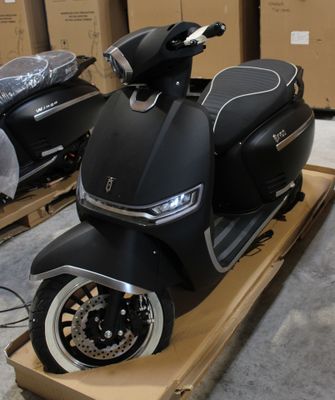un scooter posé sur un chariot dans un entrepôt