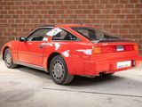 an image of a red car parked in front of a brick wall
