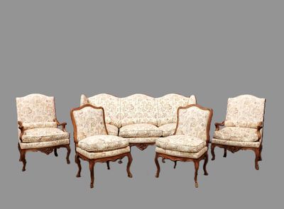 six chaises et un canapé alignés sur un fond gris