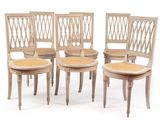 four wooden chairs with wicker seats on a white background