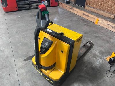 un chariot élévateur jaune et noir dans un entrepôt, avec d'autres équipements en arrière-plan