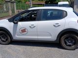a small white car parked on the side of the road