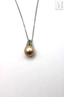 a close up of a necklace with a pearl on a chain