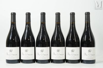 six bottles of wine are lined up on a white surface