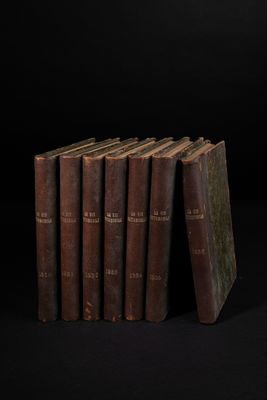 six vieux livres empilés les uns sur les autres sur une surface noire