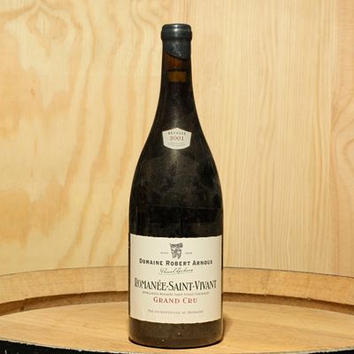 a bottle of wine sitting on top of a wooden barrel