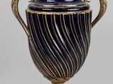 un vase bleu et or posé sur un socle