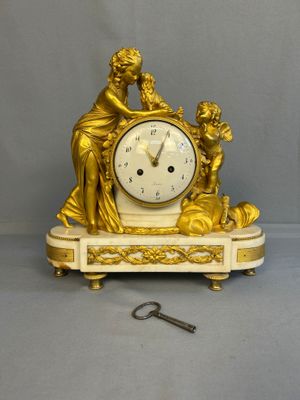 a gold clock that is sitting on a table next to a key