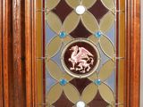 a wooden cabinet with a glass door with a horse on it