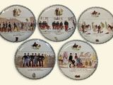 four plates with different images of people on them on a white surface