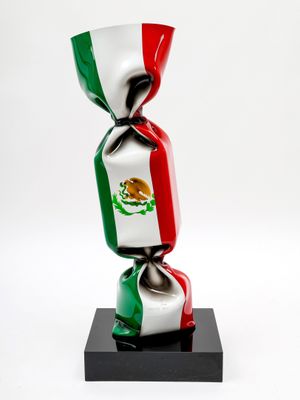 bonbon emballé dans le drapeau mexicain, posé sur un support noir devant un fond blanc