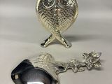 a silver vase and spoon sitting next to each other