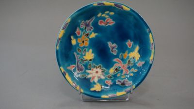 a blue and yellow bowl with flowers on it