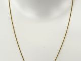 un collier en or orné de trois breloques autour du cou d'un mannequin