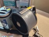 a small fan sitting on a table next to a box