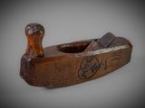 an old wooden plane with a wooden handle on a gray surface