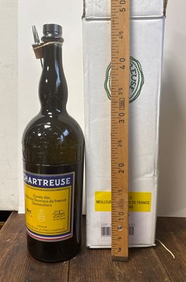 une bouteille de vin posée sur une table à côté d'une règle