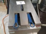 a picture of a commercial fryer with two blue tongs on it