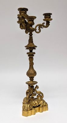 pair of antique brass candelabs on a stand