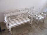 un banc blanc et deux chaises dans une pièce