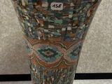 a vase that is sitting on the floor with a tag on it
