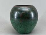 un vase vert posé sur une table