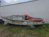 un bateau posé dans l'herbe à côté d'un bâtiment