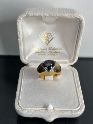a gold ring with a black stone inside of it
