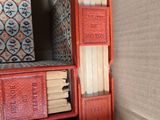 a stack of books sitting on a shelf next to a toilet