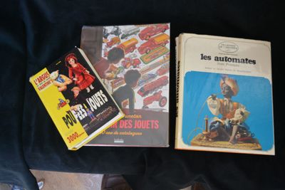 three books that are sitting on a black cloth