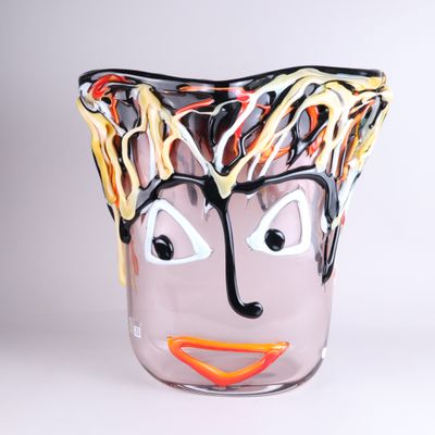 un vase en verre sur lequel est peint un visage