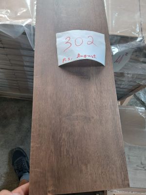 une personne tenant un morceau de bois sur lequel est accrochée une étiquette de prix