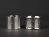 a pair of silver cups with engraved names on them