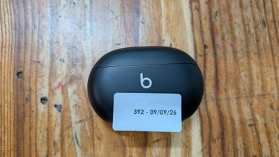 des AirPods noirs posés sur une table en bois