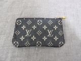 a close up of a louis vuitton coin purse on a table