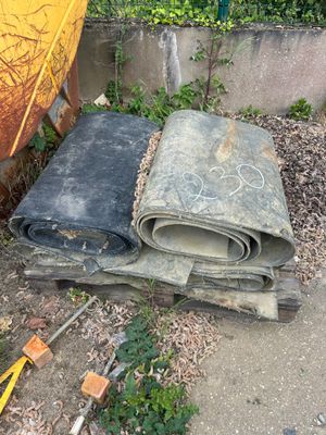 un tas de vieux matelas posé par terre à côté d'un parapluie jaune