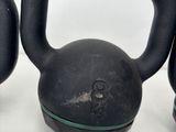three black kettle weights sitting on top of a white surface