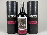 trois bouteilles de « vin du diable » posées les unes à côté des autres sur une table