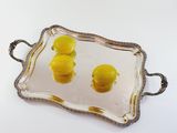 a tray with lemons on it on a white surface