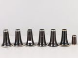 six vases noirs et blancs sont alignés sur une surface blanche